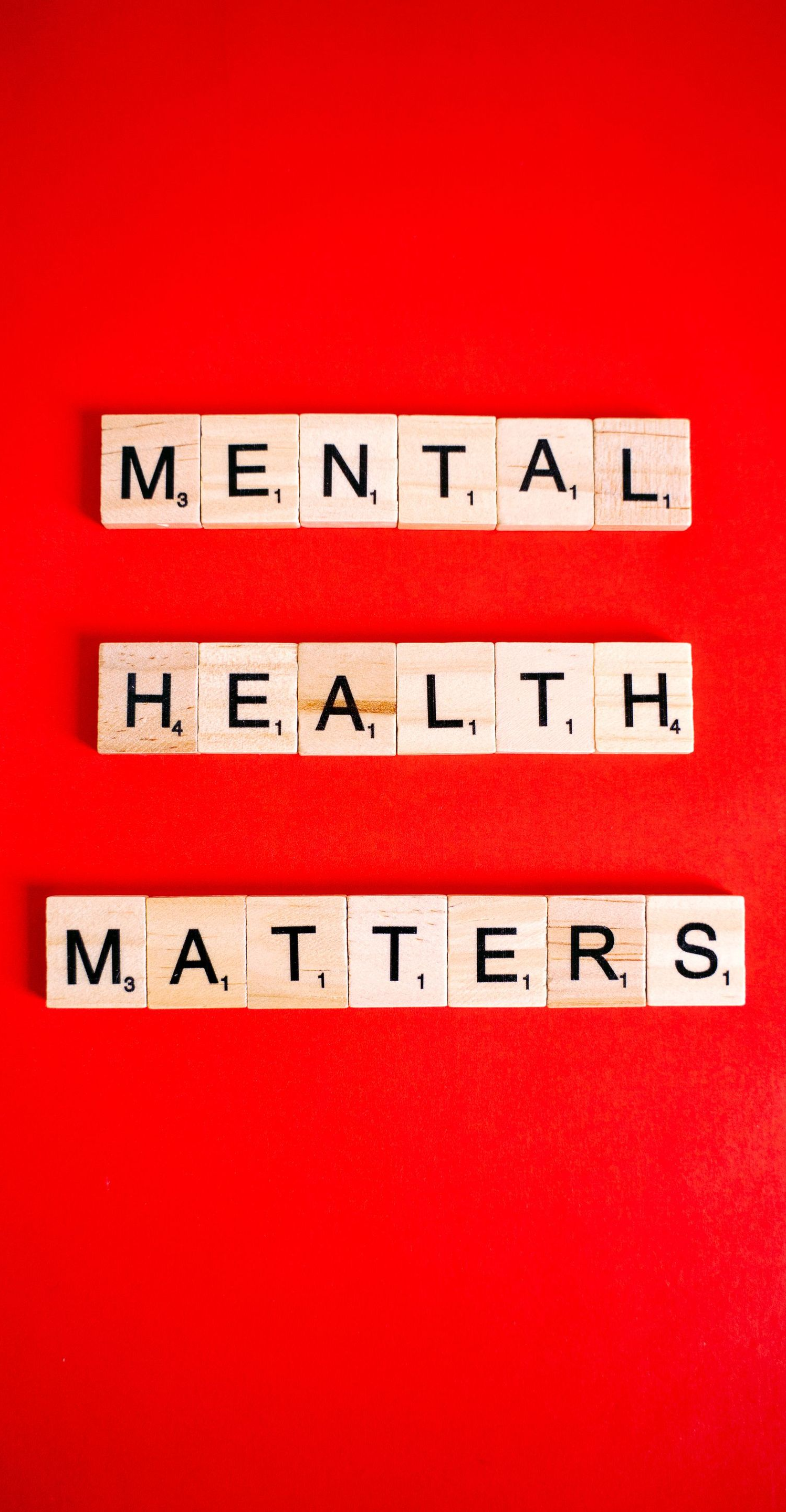 Scrabble tiles on a red background spell “MENTAL HEALTH MATTERS.”