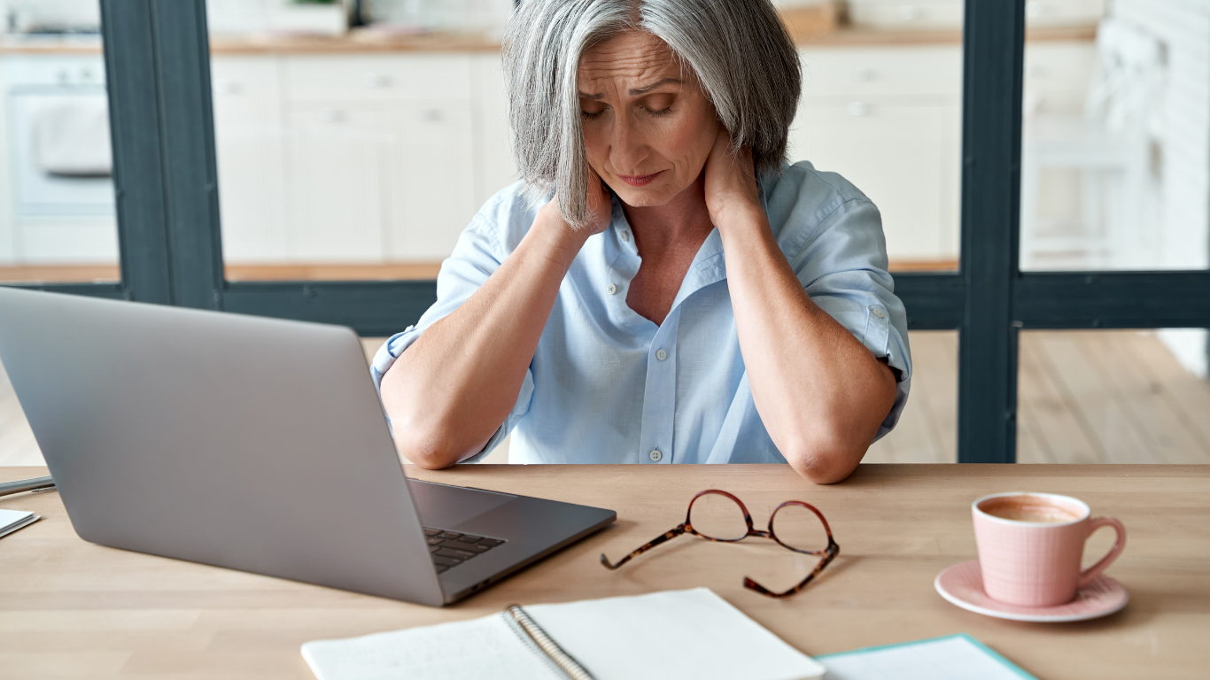 a woman is sitting at a table with a laptop and a cup of coffee .