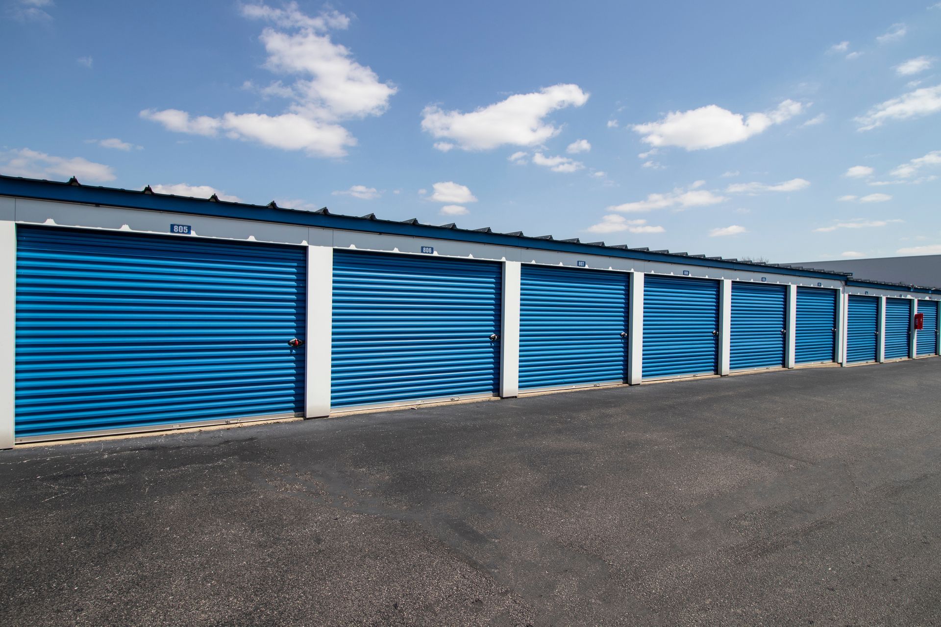 A row of blue garage doors on a sunny day