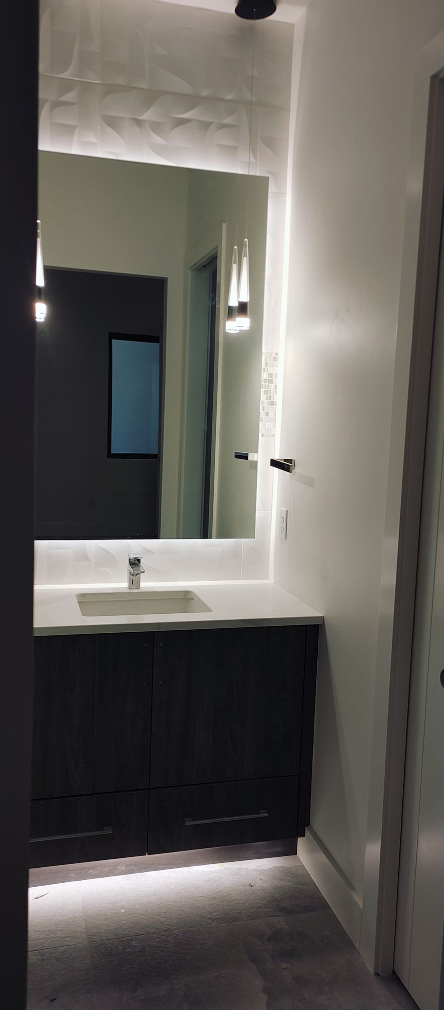 A bathroom with a sink and a large mirror.