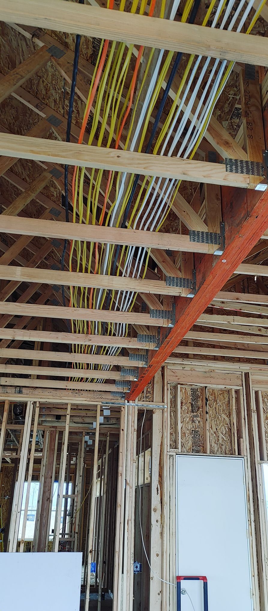 A building under construction with a lot of wires hanging from the ceiling.