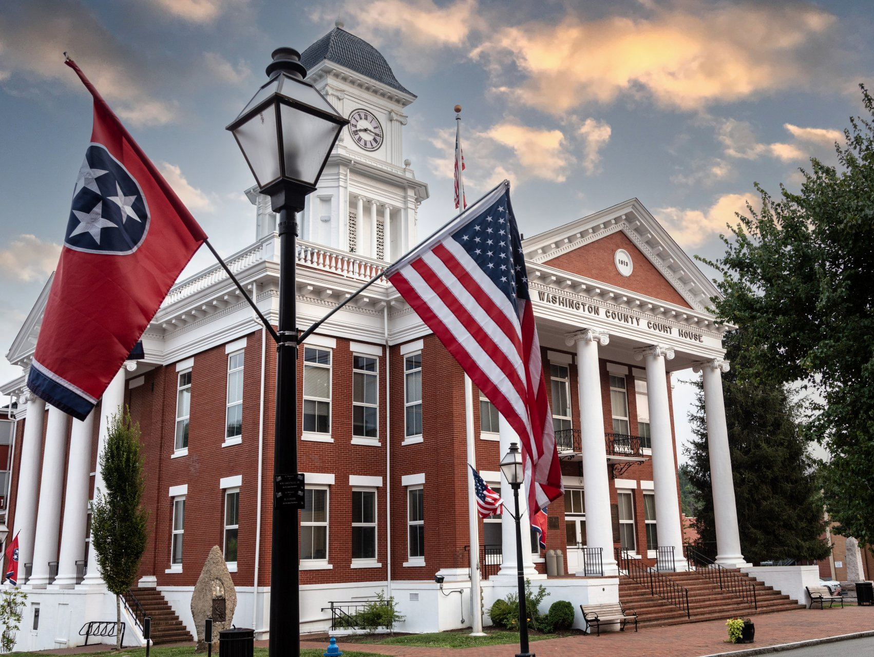 A man in a white shirt and tie is sitting at a desk reading a book – Jonesborough, TN - Law Offices of James R Wheeler