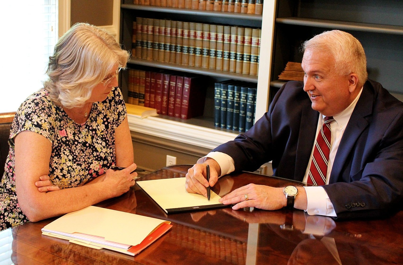 A man in a suit and tie is sitting at a table with a woman – Jonesborough, TN - Law Offices of James R Wheeler