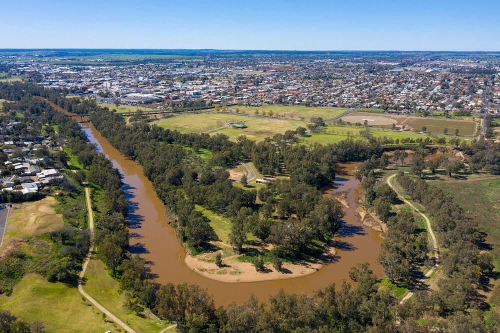 An Aerial View Of A River Surrounded By Trees And A City — Central West Budget Tree Services in Dubbo, NSW