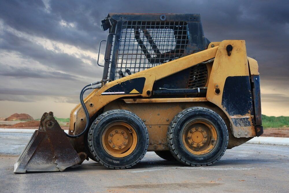 A Small Yellow Bulldozer Is Parked On The Side Of The Road — Central West Budget Tree Services in Dubbo, NSW