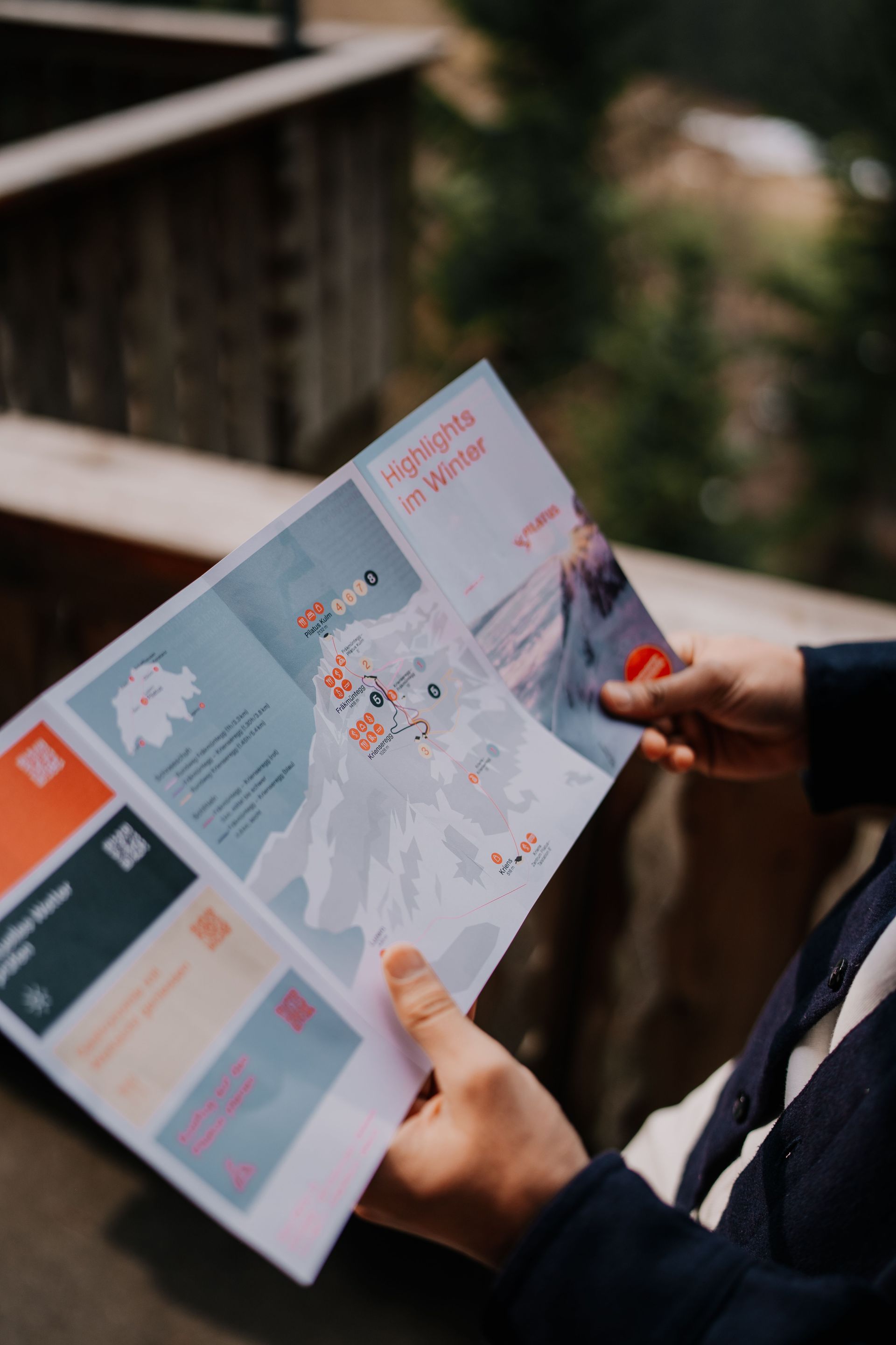 A tourist in Switzerland is holding an information pamphlet for Mount Pilatus