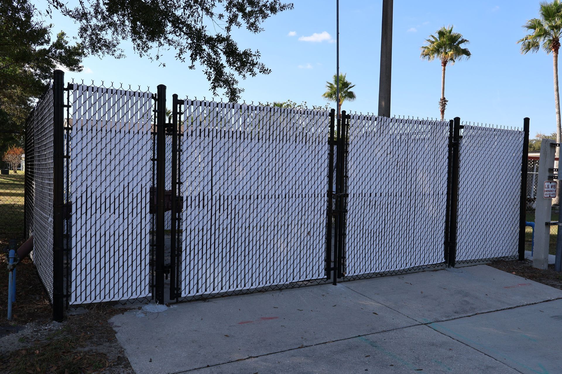 Commercial chain link and white vinyl enclosure with black aluminum posts in Tampa, FL