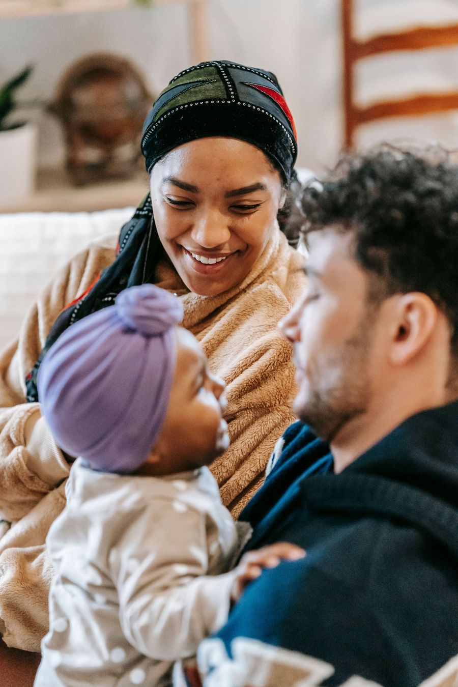 Multi-generational family smiling together on a couch in a bright living room