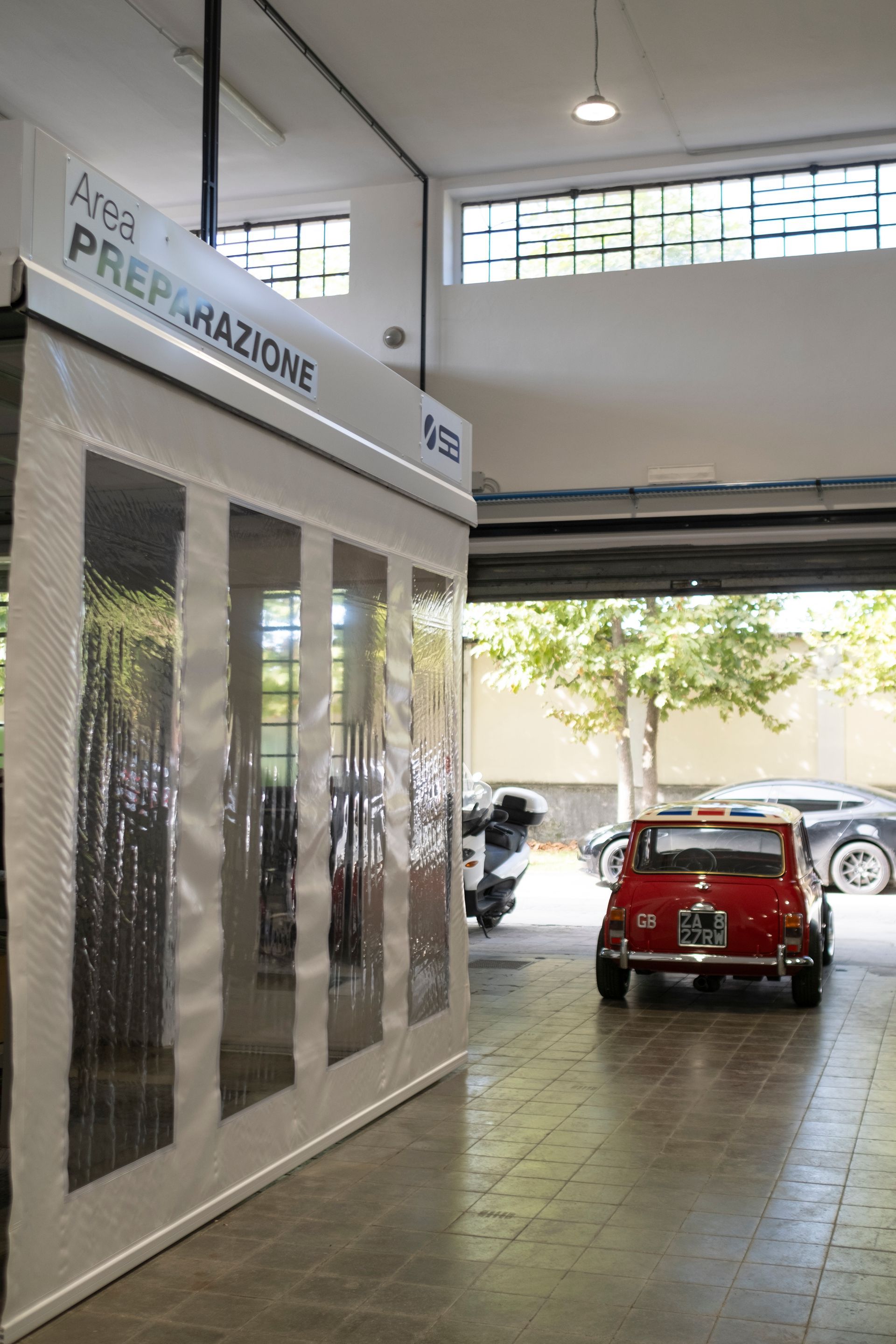 auto rossa fuori da una cabina di verniciatura