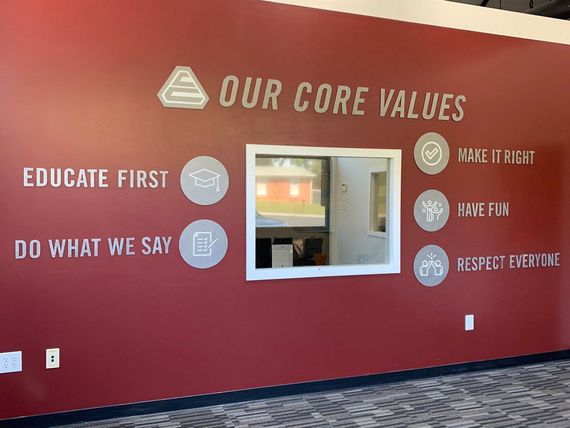 Red wall with “Our Core Values” text and icons beside a small window and white trim.