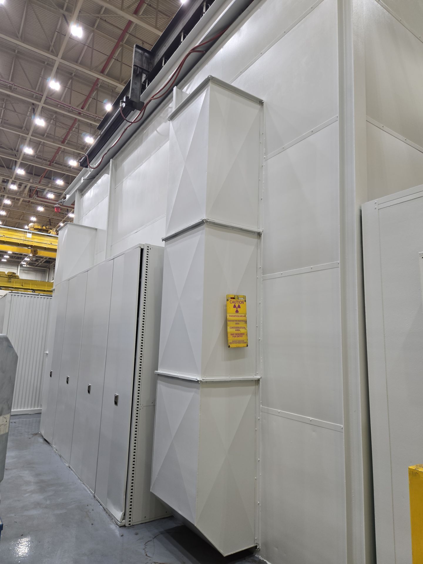 Industrial white fabric-covered storage enclosures inside a warehouse under bright overhead lights
