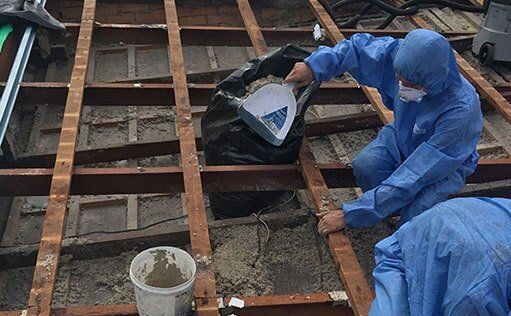 Worker In Full Gear Removing Asbestos — Roofing Services in Rockhampton, QLD Worker In Full Gear Removing Asbestos — Roofing Services in Rockhampton, QLD