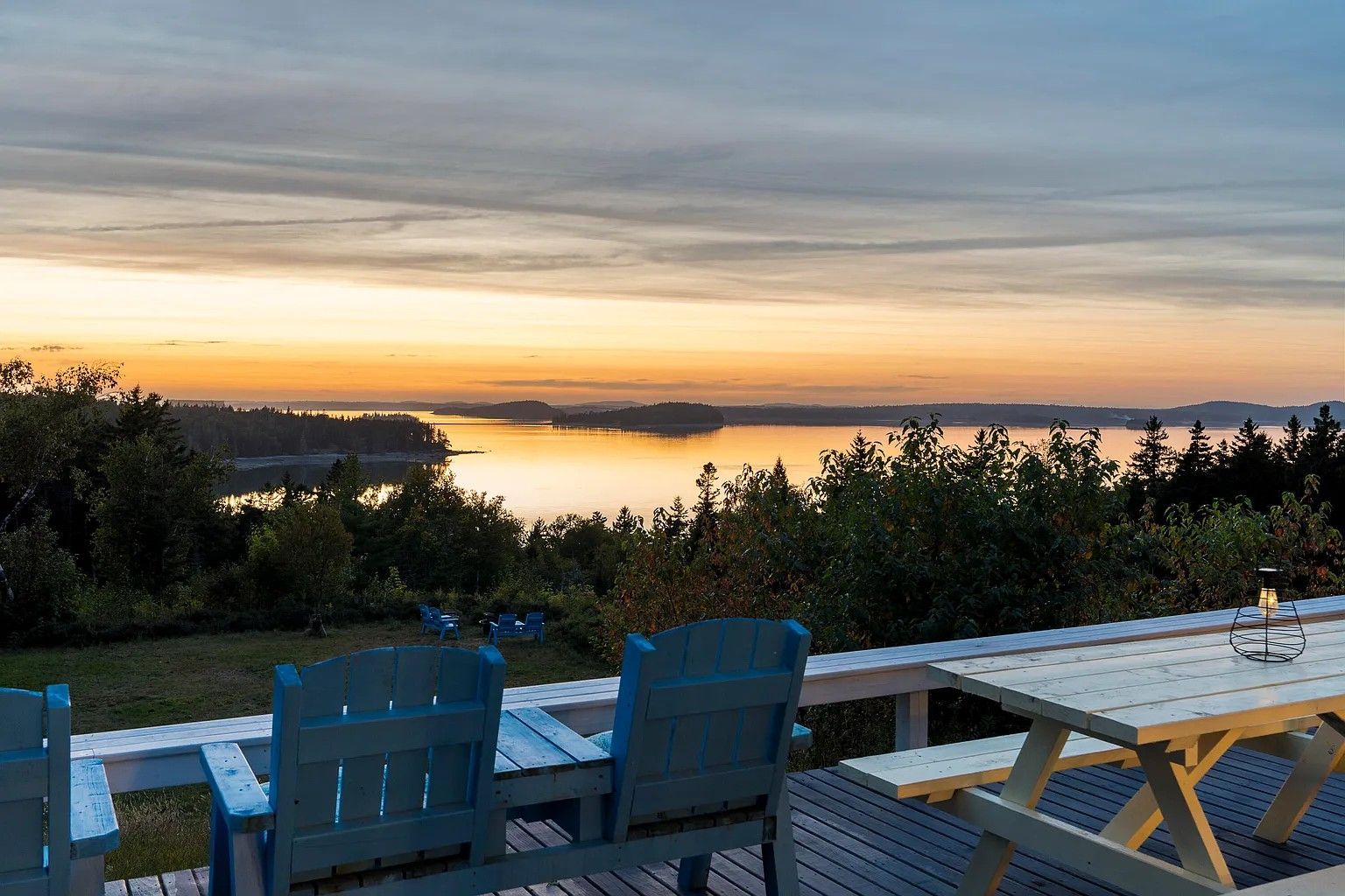 A picnic table and chairs on a deck overlooking Frenchman Bay located at the Bluff House Inn, near the quiet side of Acadia.