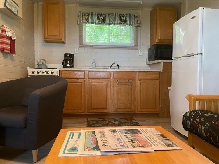A living room with a couch and a table with newspapers on it