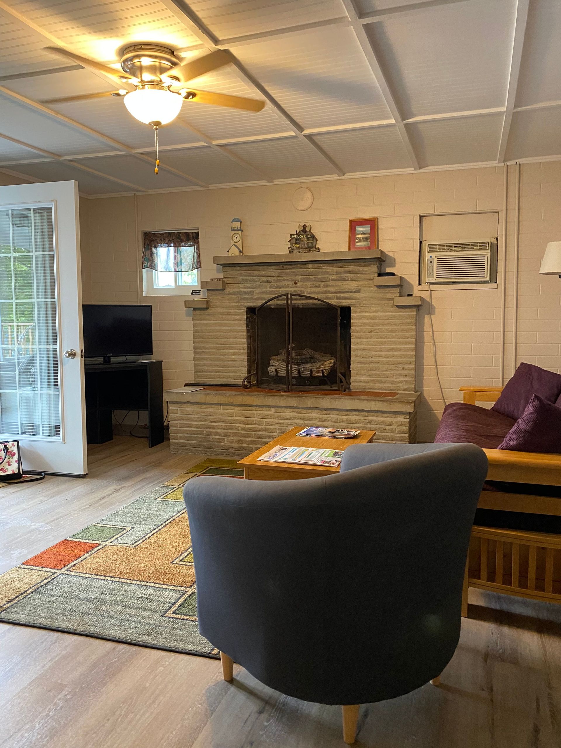 A living room with a fireplace and a ceiling fan