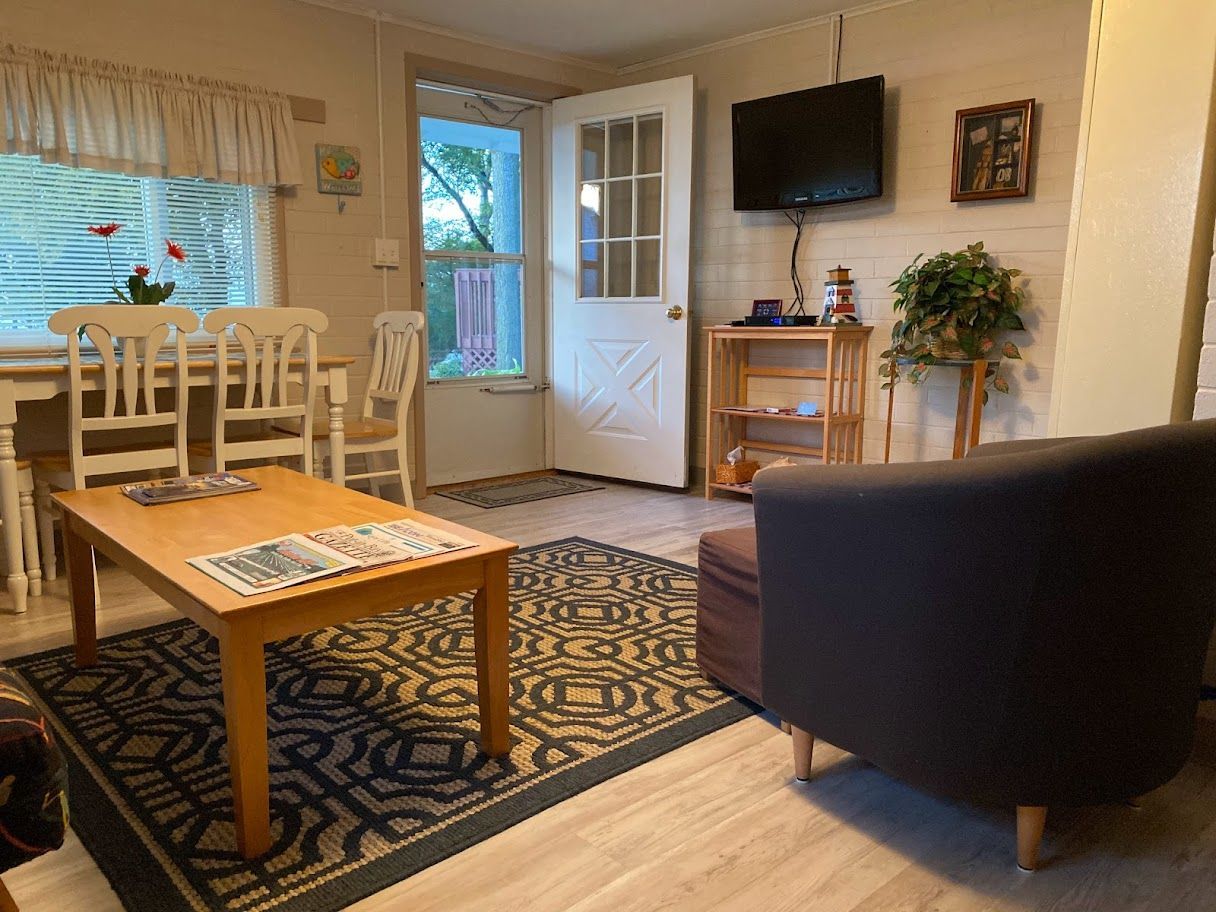 A living room with a table , chairs , and a television.