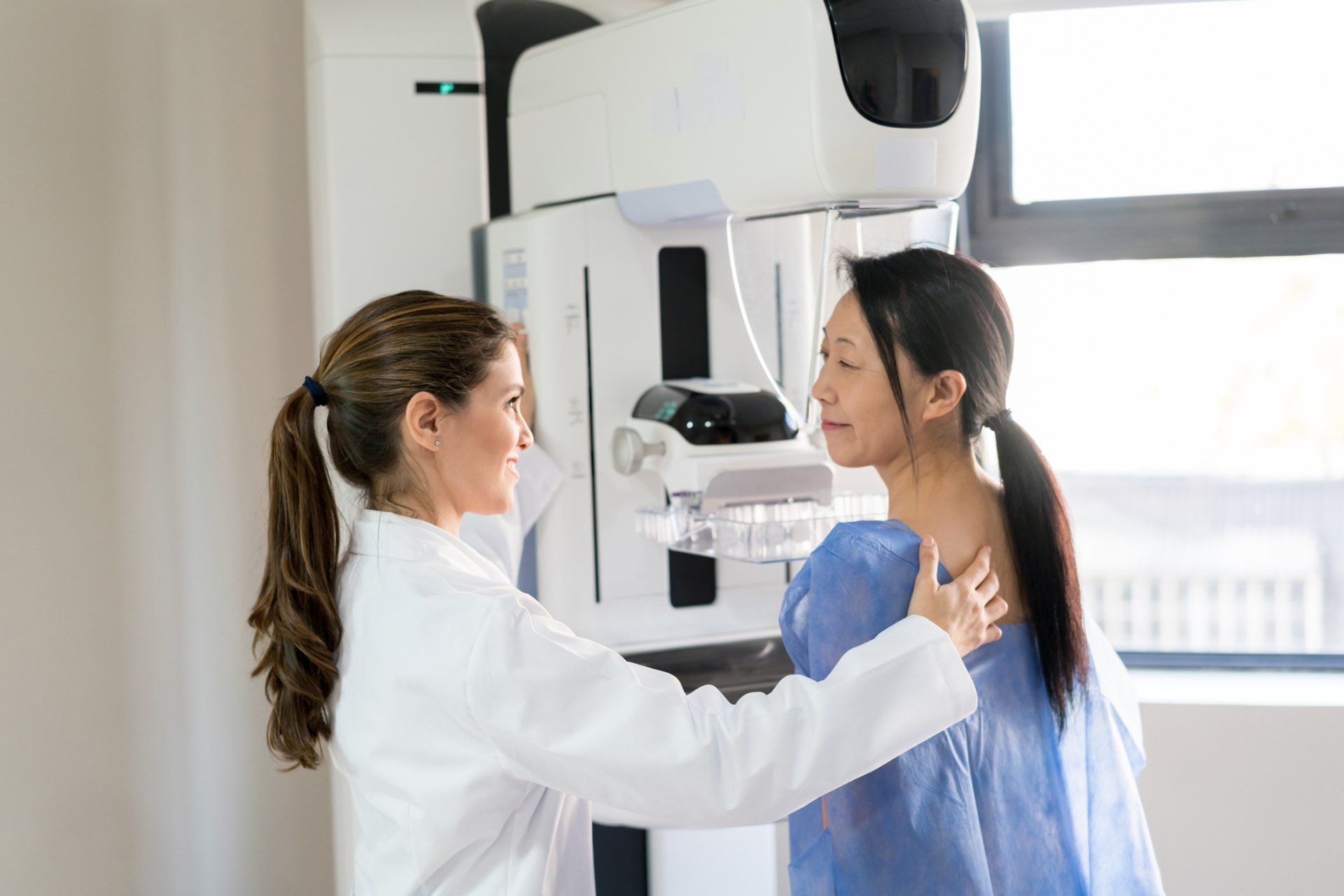 Friendly female doctor talking to her patient and adjusting her position — New Hartford, NY — Oxford Medical Imaging