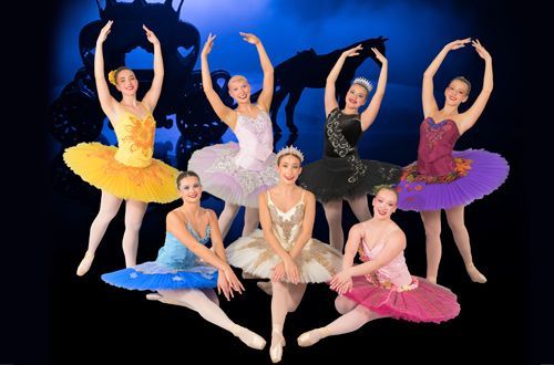 Six ballet dancers in colorful tutus posing against a black background