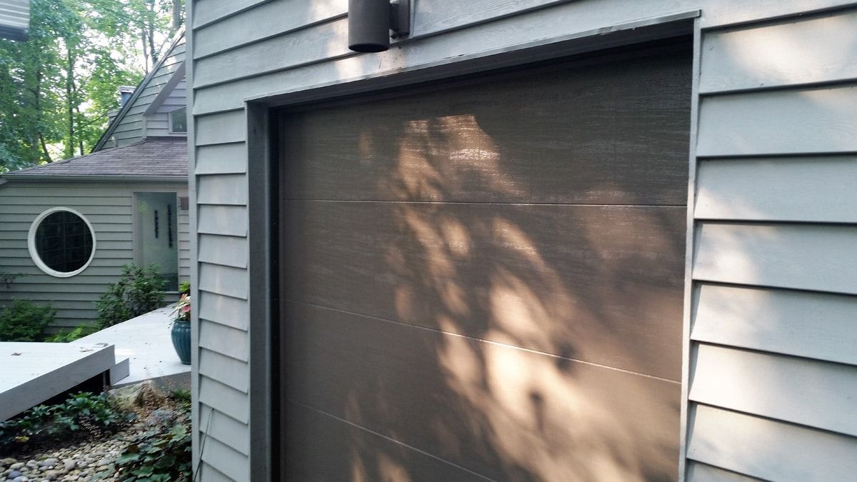 A garage door with a shadow of a tree on it