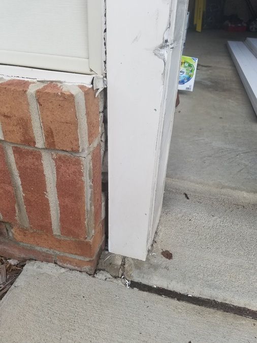A brick wall with a white trim and a white door.