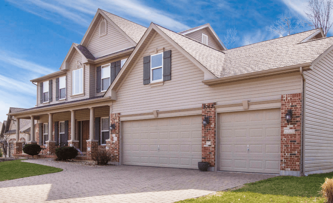 A large house with two garage doors and a porch.