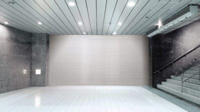 a large empty room with stairs and a white wall .