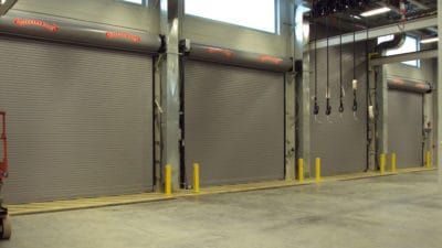 a large warehouse with a lot of roller shutters on the walls .
