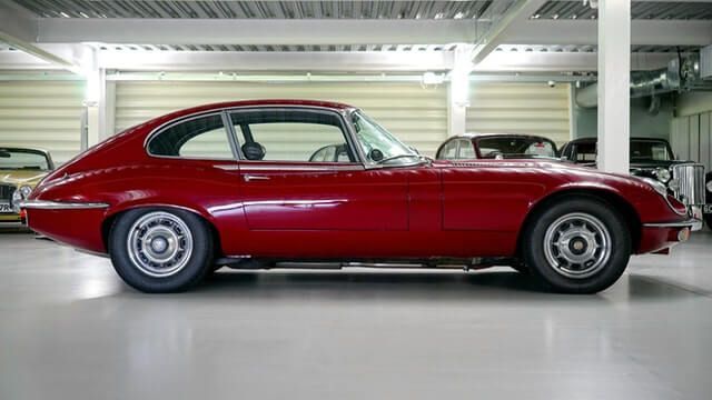 A red sports car is parked in a garage.