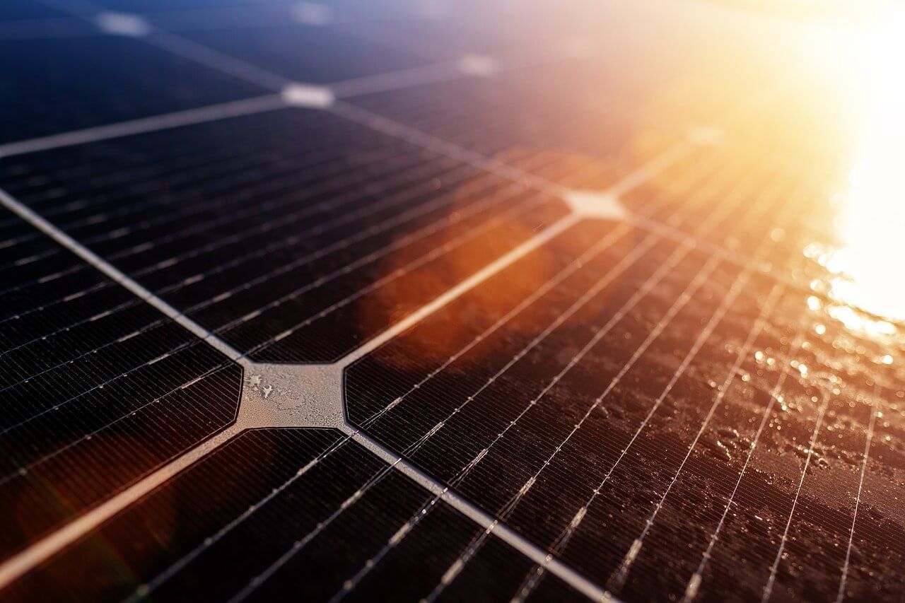A close up of a solar panel with the sun shining through it.