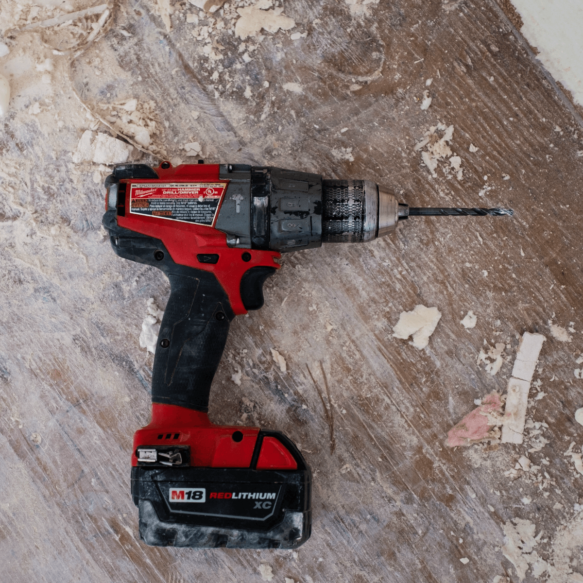 a red and black cordless drill is sitting on a wooden surface