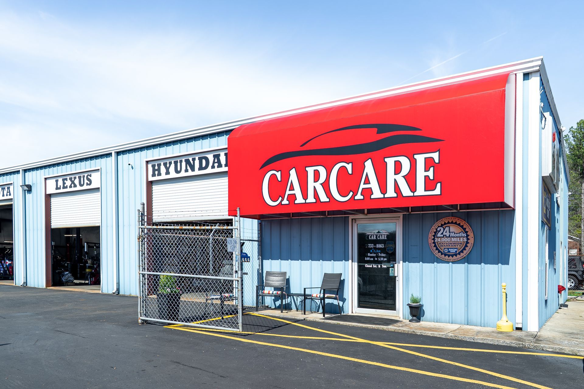 Carcare auto service building with a red sign and Hyundai dealership storefront on a sunny day
