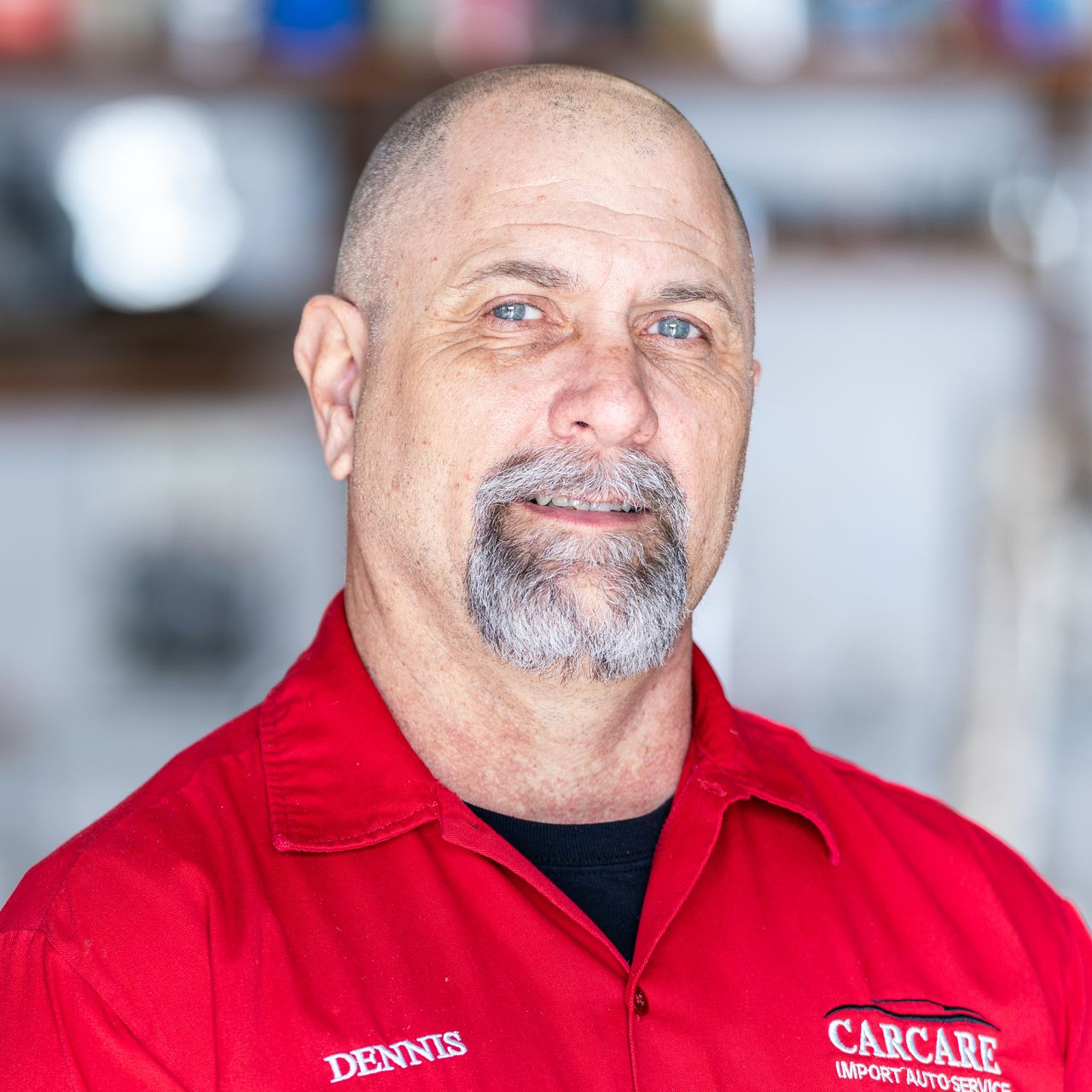 Portrait of a smiling man in a red CAR CARE uniform shirt