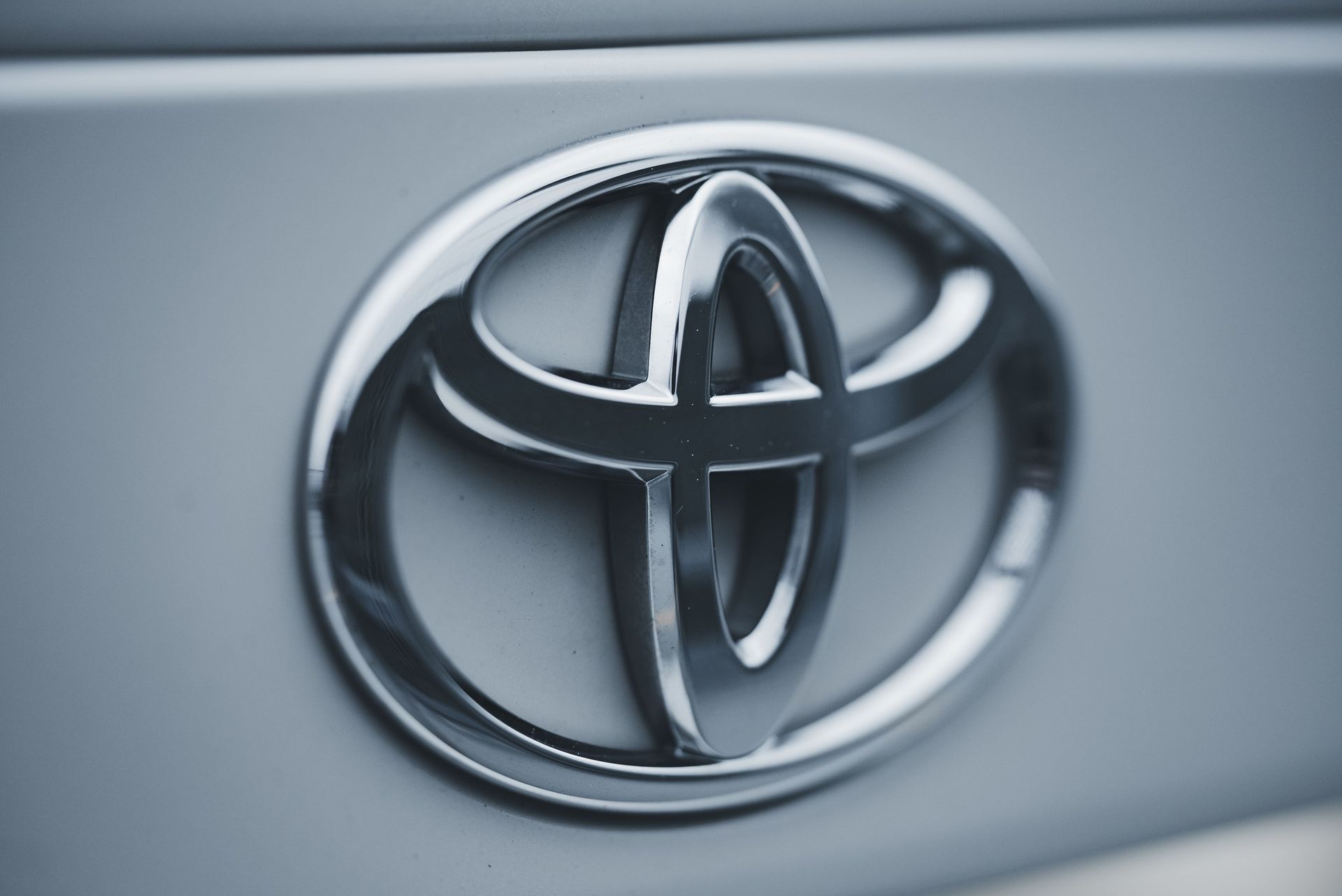 Close-up of a silver Toyota emblem on a car grille