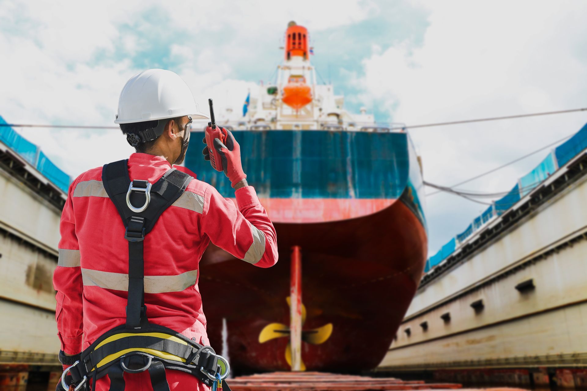 A Man is Talking on a Walkie Talkie in Front of a Large Ship