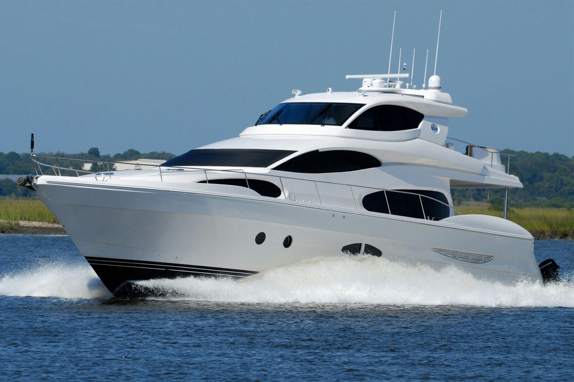 White motor yacht speeding across blue water