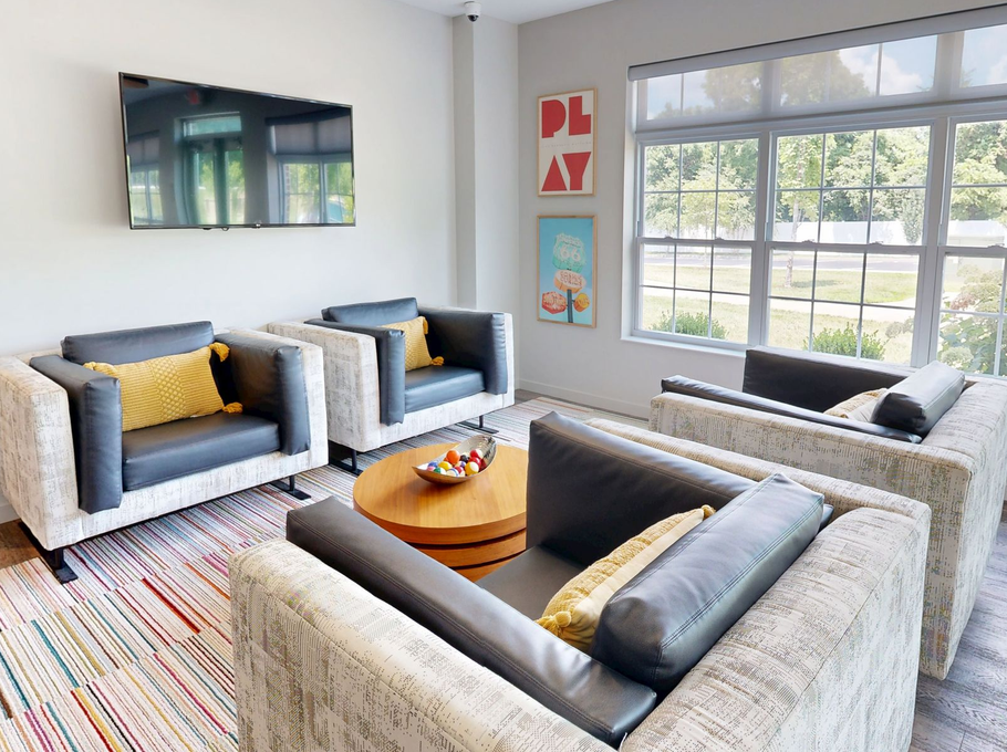 Modern lounge area with couches, bar, coffee table, and stools.