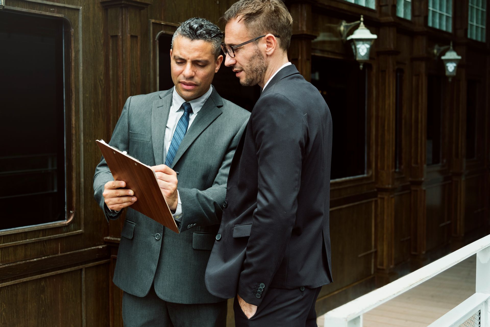 Senior couple reviews document with a professional at a table; indoor setting.