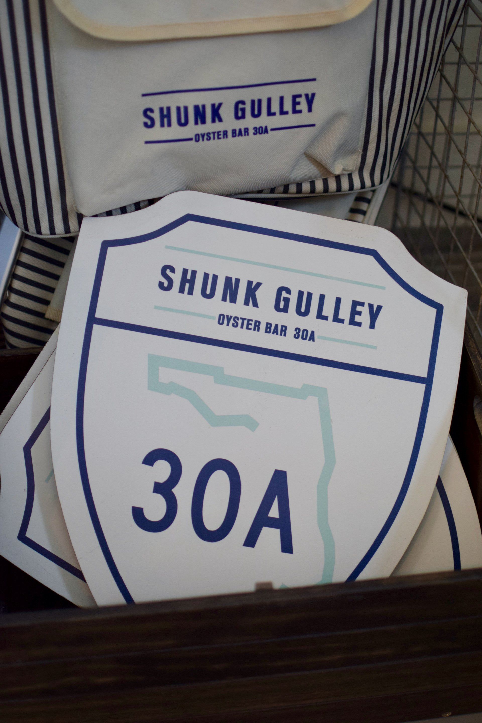 Shunk Gulley surf shop sign with large “30A” logo in blue and white.