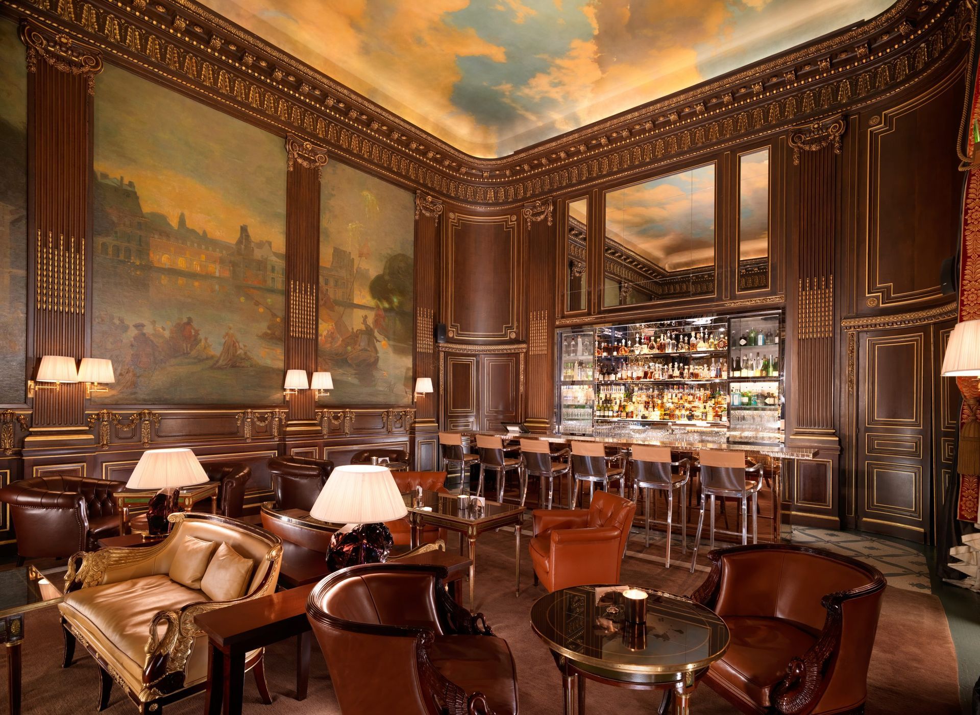 Luxurious bar interior with dark wood paneling, ornate paintings, and patrons at tables. Le Meurice 