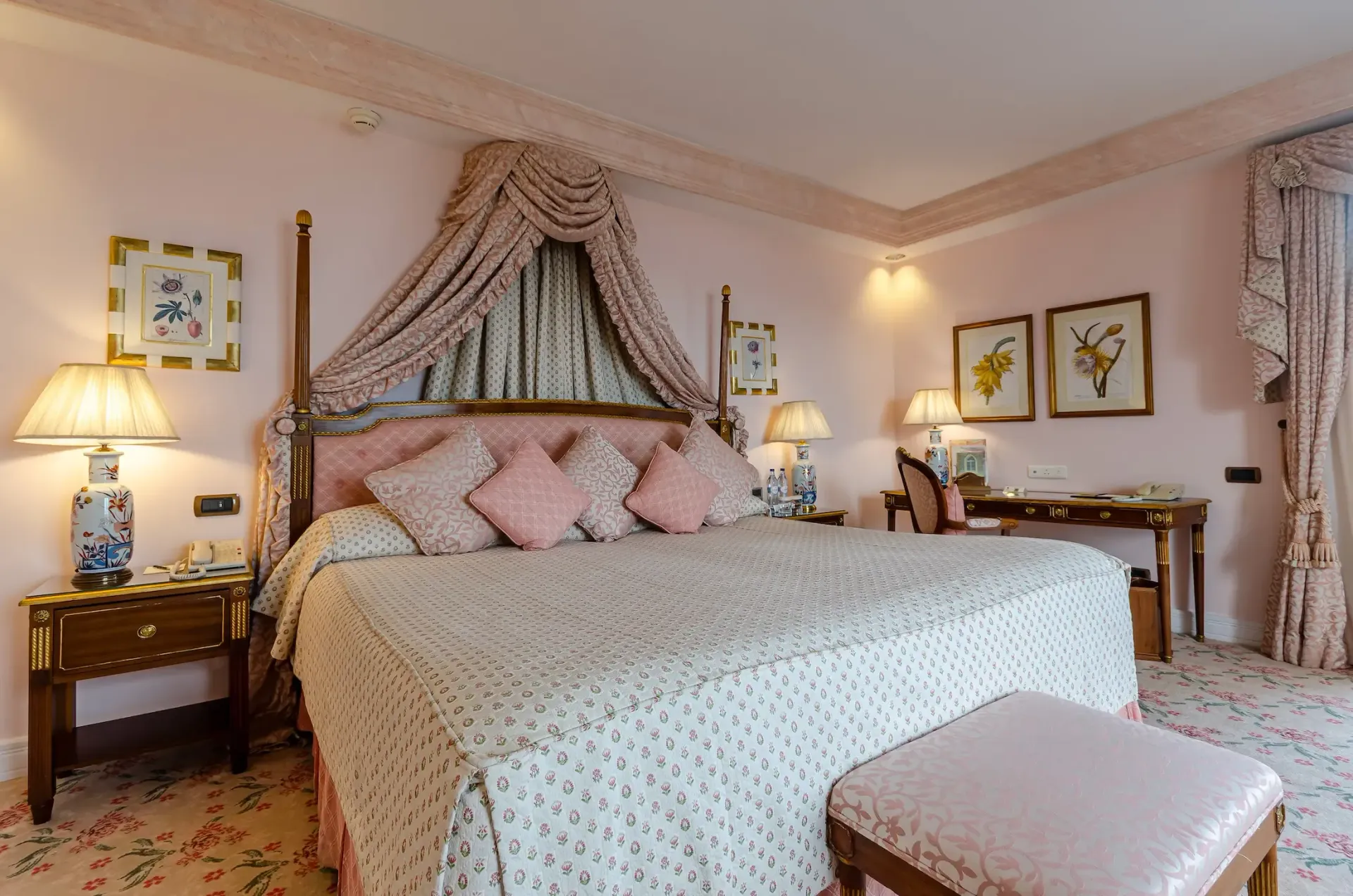 Elegant bedroom with a four-poster bed, soft pink decor, bedside lamps, and a bright window curtain Olissippo Lapa Palace