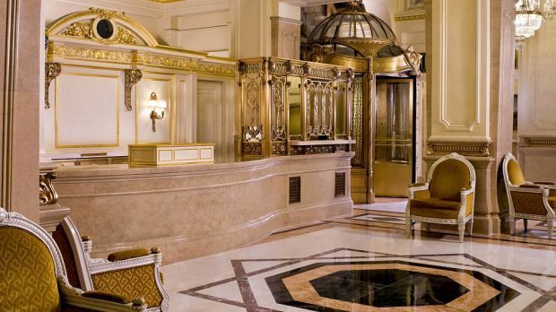 Ornate hotel lobby with a marble reception desk and gilded accents. St. Regis New York hotel