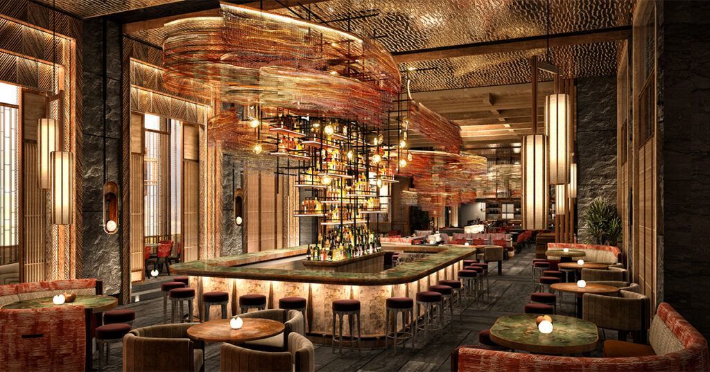 Elegant bar interior with central bar, seating, and elaborate chandelier.