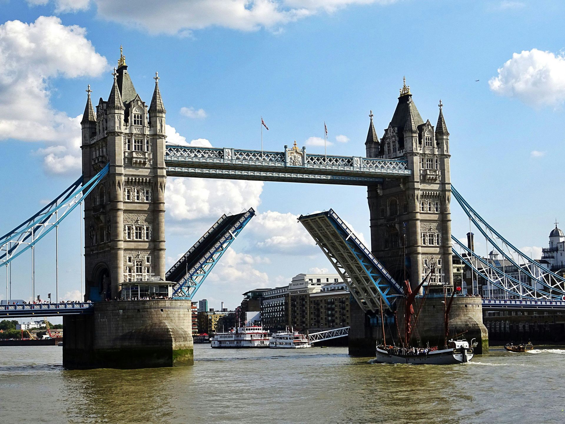 Tower Bridge in London, England, open for boat passage; blue sky and water.