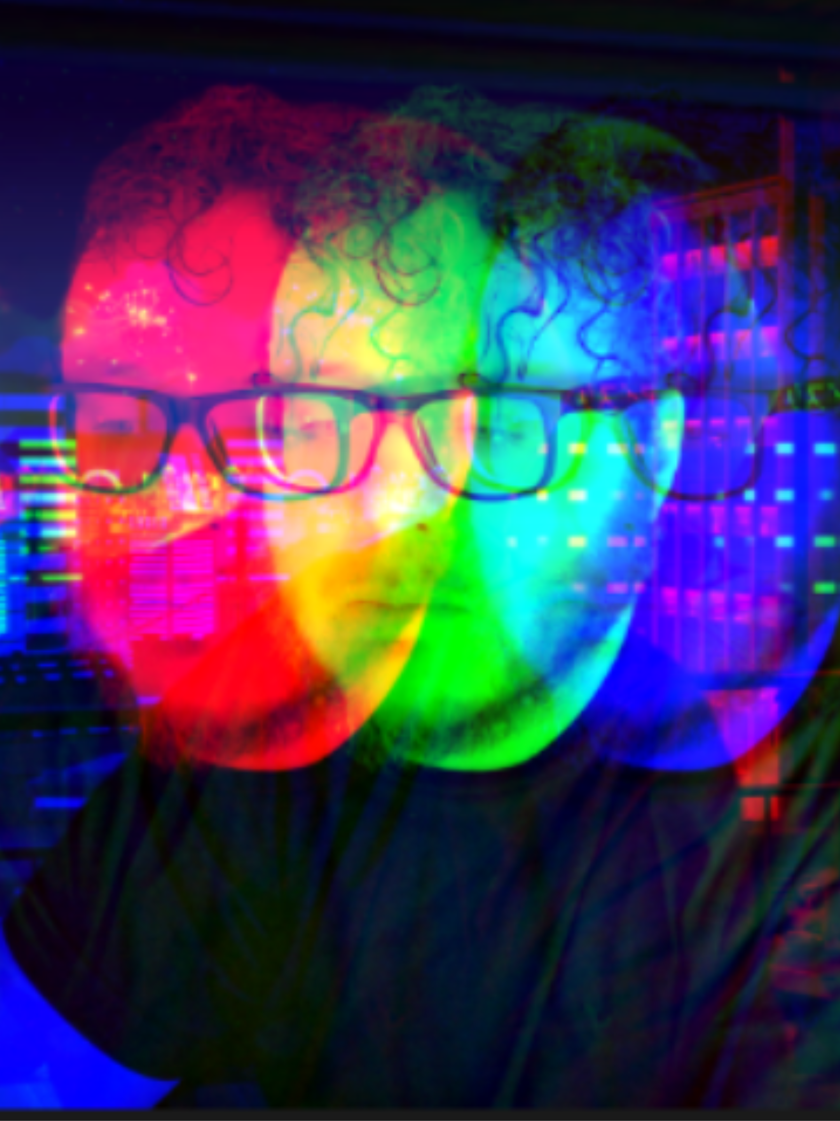 A man wearing glasses is surrounded by colorful lights.