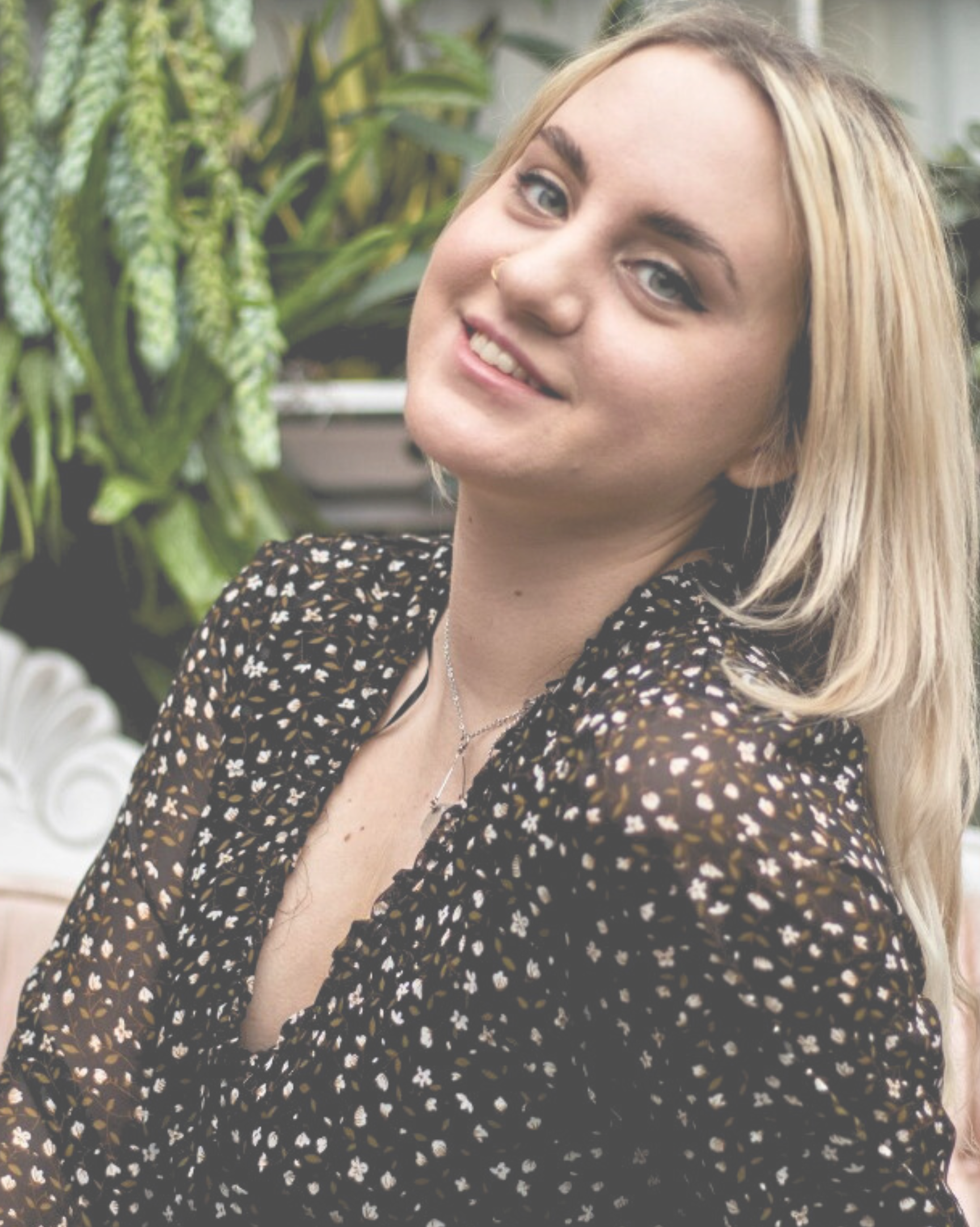 A woman in a black and white polka dot dress is smiling for the camera.