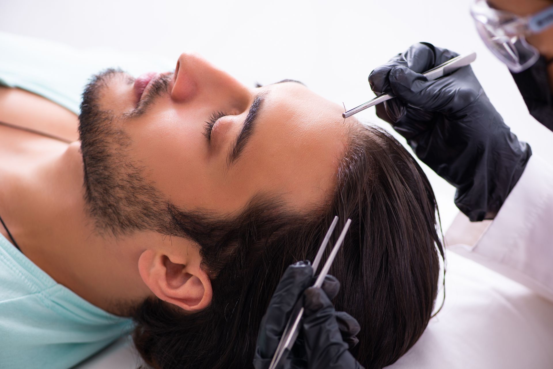 Ein Mann bekommt in einem Friseursalon eine Spritze in den Kopf.