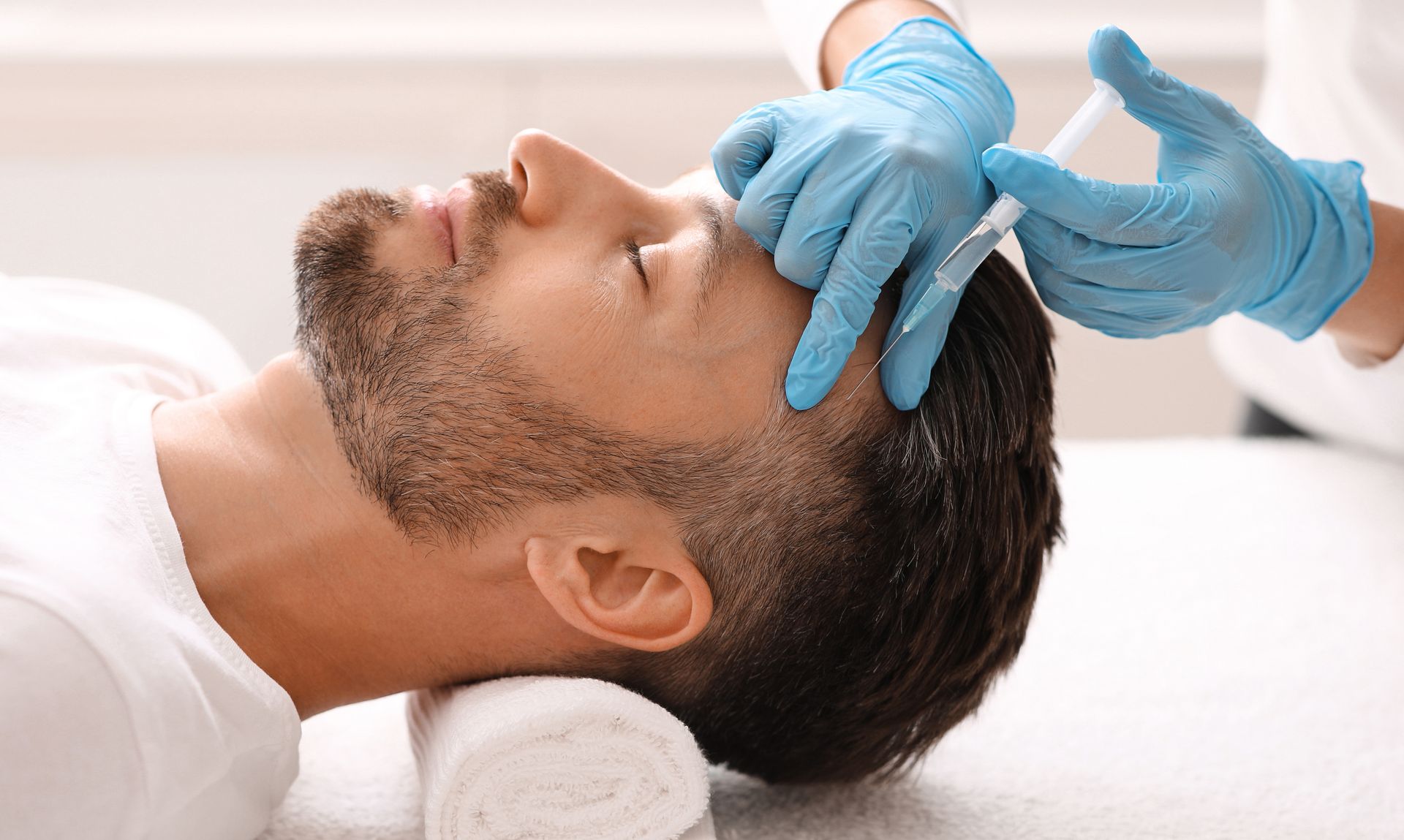 Ein Mann bekommt in einem Schönheitssalon eine Spritze in den Kopf.