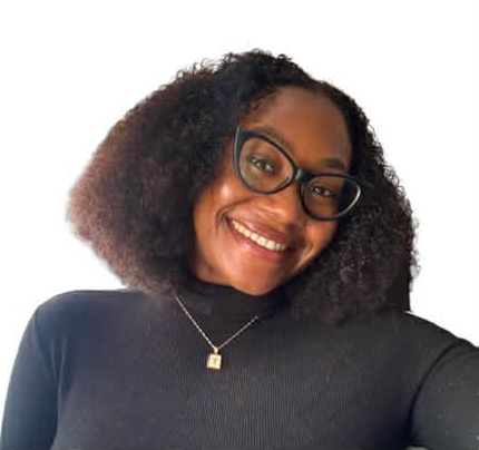 Smiling person with curly hair and glasses in a black top against a white background