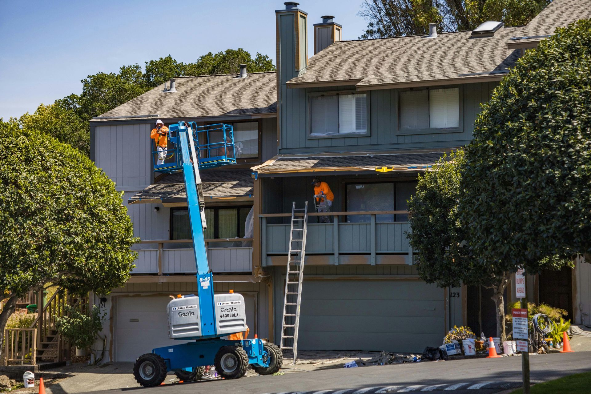 Two men are working on the roof of a house.