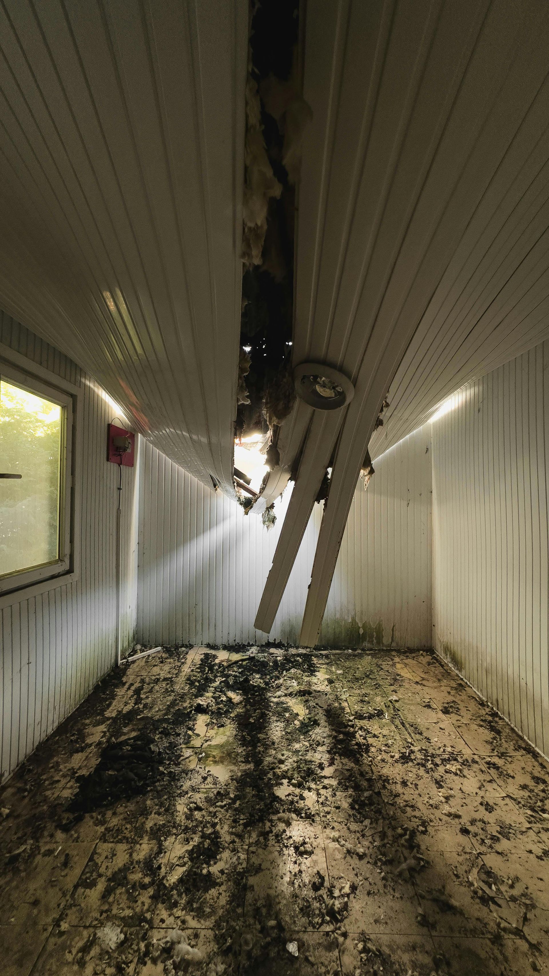 Emergency roofing repair vs full roof replacement comparison featuring major ceiling damage from a roof leak